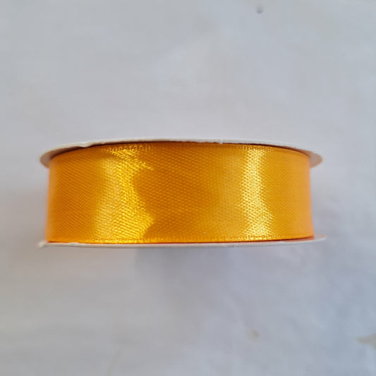 A roll of 2cm amber coloured satin ribbon